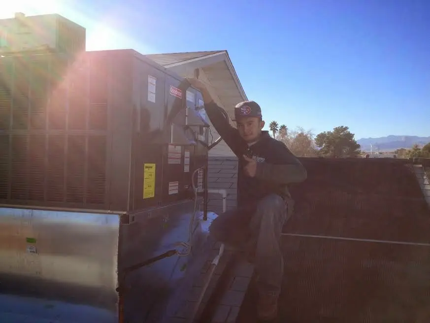 HVAC technician performing Boiler Repair on a rooftop unit in Yankton