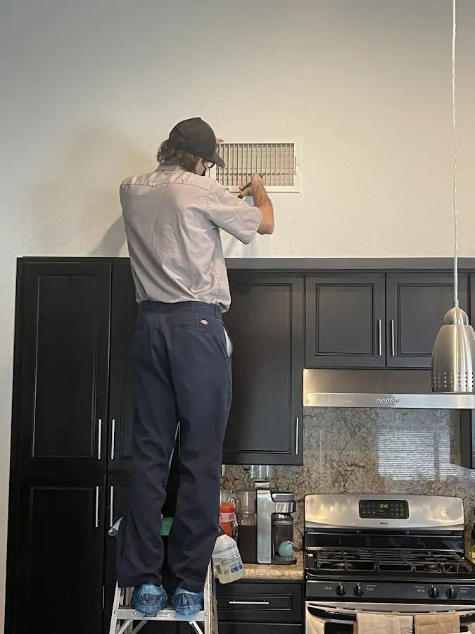 Technician inspecting an air vent during HVAC service in Yankton